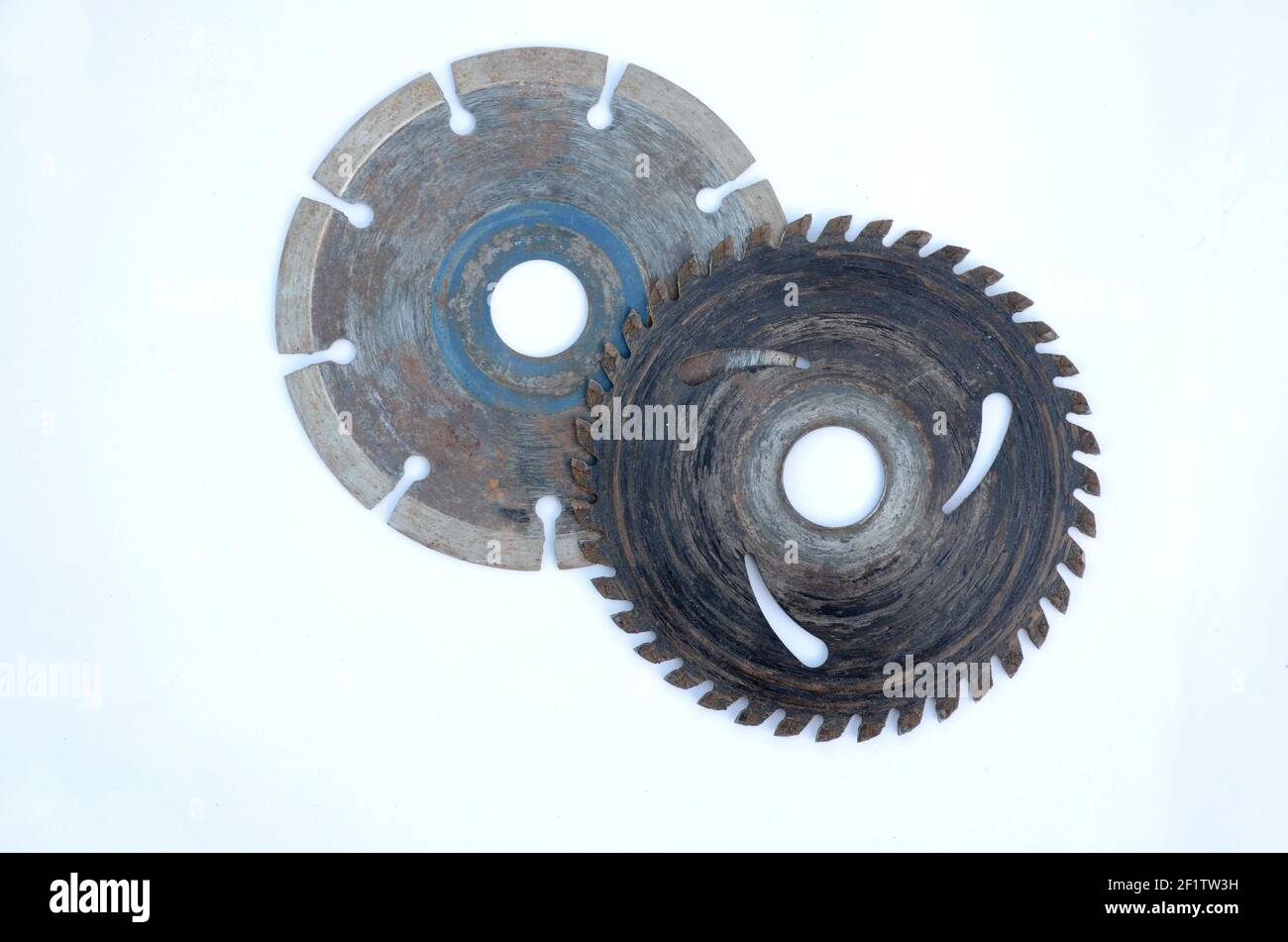 Un gros plan d'anciens engrenages métalliques et de lames rondes isolé sur un fond blanc Banque D'Images