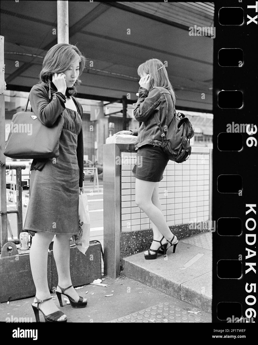 Des filles portant des talons hauts en utilisant un téléphone portable à Tokyo, au Japon Banque D'Images