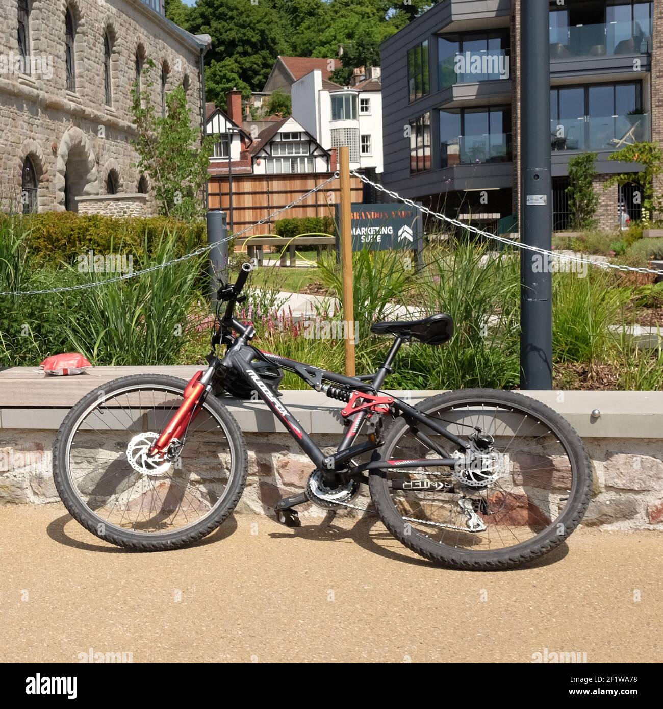 Mai - vélo de montagne bon marché juste laissé déverrouillé à côté d'un nouveau jardin dans un immeuble Banque D'Images