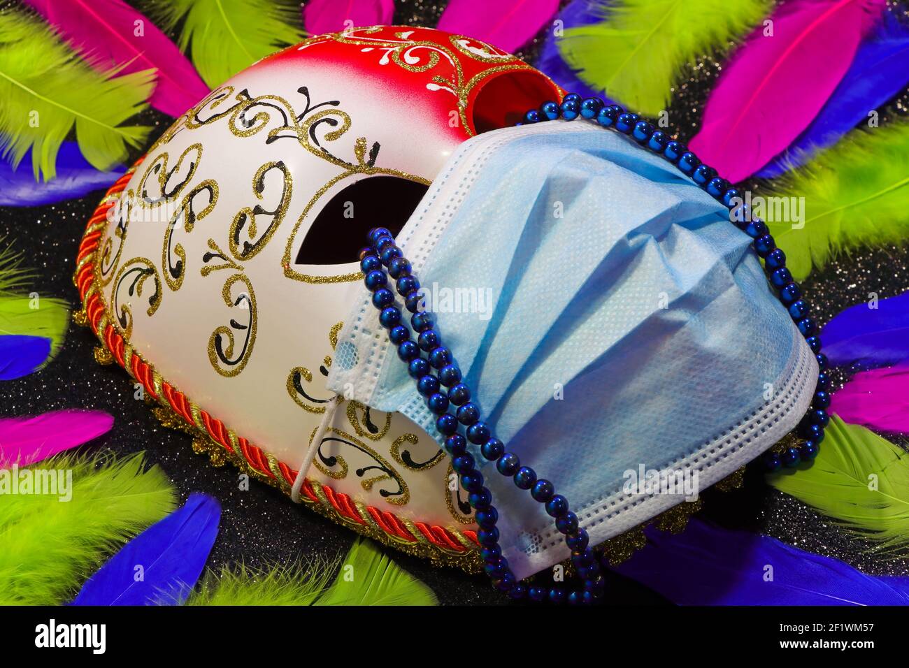 Masque de carnaval et masque chirurgical avec des larmes et des plumes de perles Banque D'Images