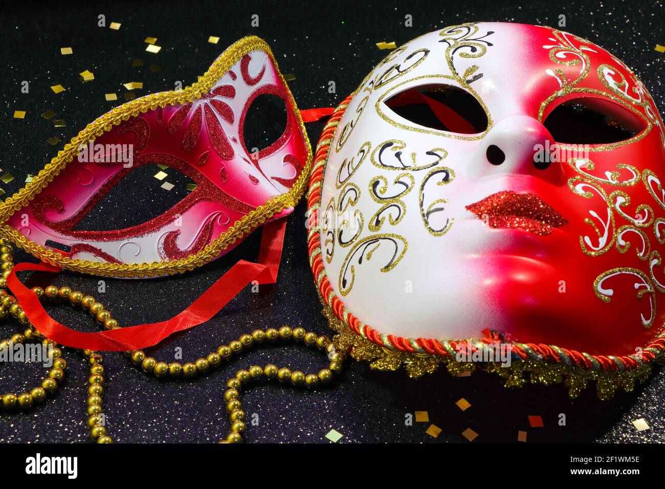 Masques de carnaval rouge et blanc avec confettis et perles d'or Banque D'Images