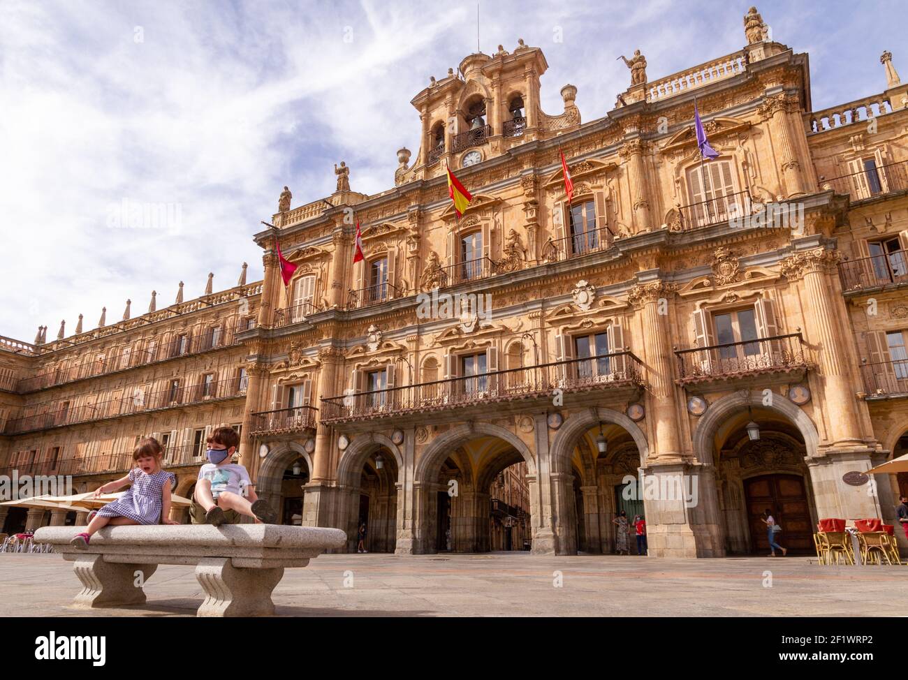 Deux enfants assis sur un banc devant Salamanca's. Hôtel de ville à Plaza Mayor Banque D'Images