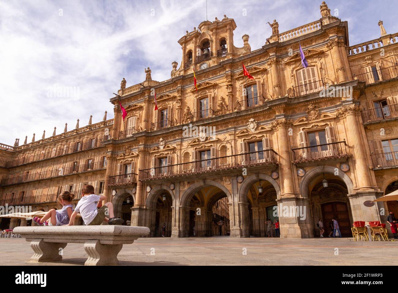 Deux enfants assis sur un banc devant Salamanca's. Hôtel de ville à Plaza Mayor Banque D'Images