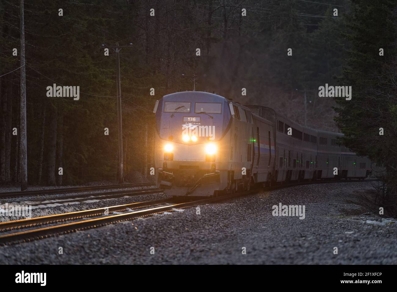 L'Empire Builder d'Amtrak s'approche du tunnel Cascade dans l'État de Washington Comme la nuit tombe sur le train couchette de Seattle à Chicago Banque D'Images
