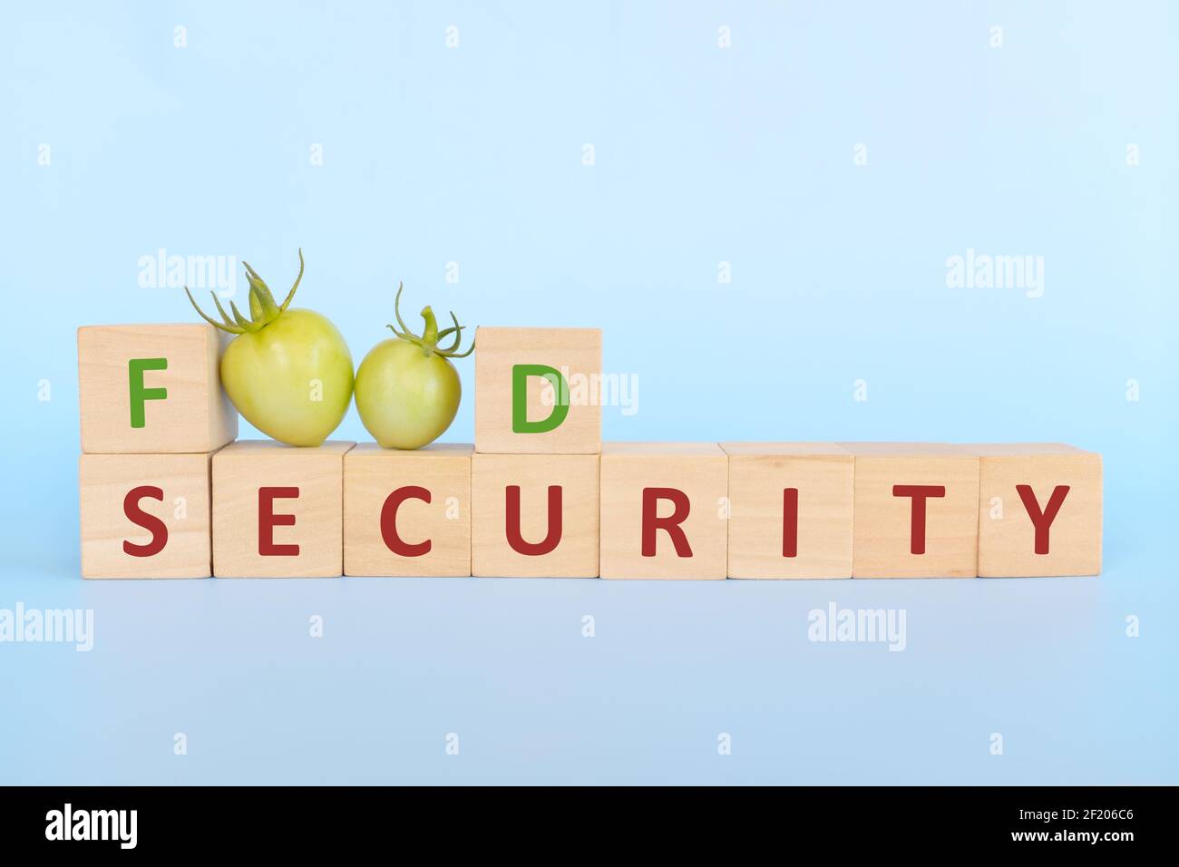 Sécurité alimentaire concept de problème mondial dans les blocs de bois et les fruits frais de tomate. Banque D'Images