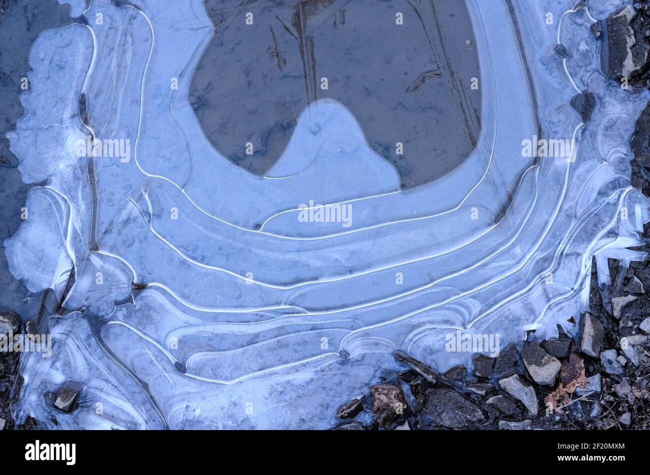 Eau gelée dans une flaque sur le sol avec structures abstraites et la surface, vue de directement au-dessus Banque D'Images
