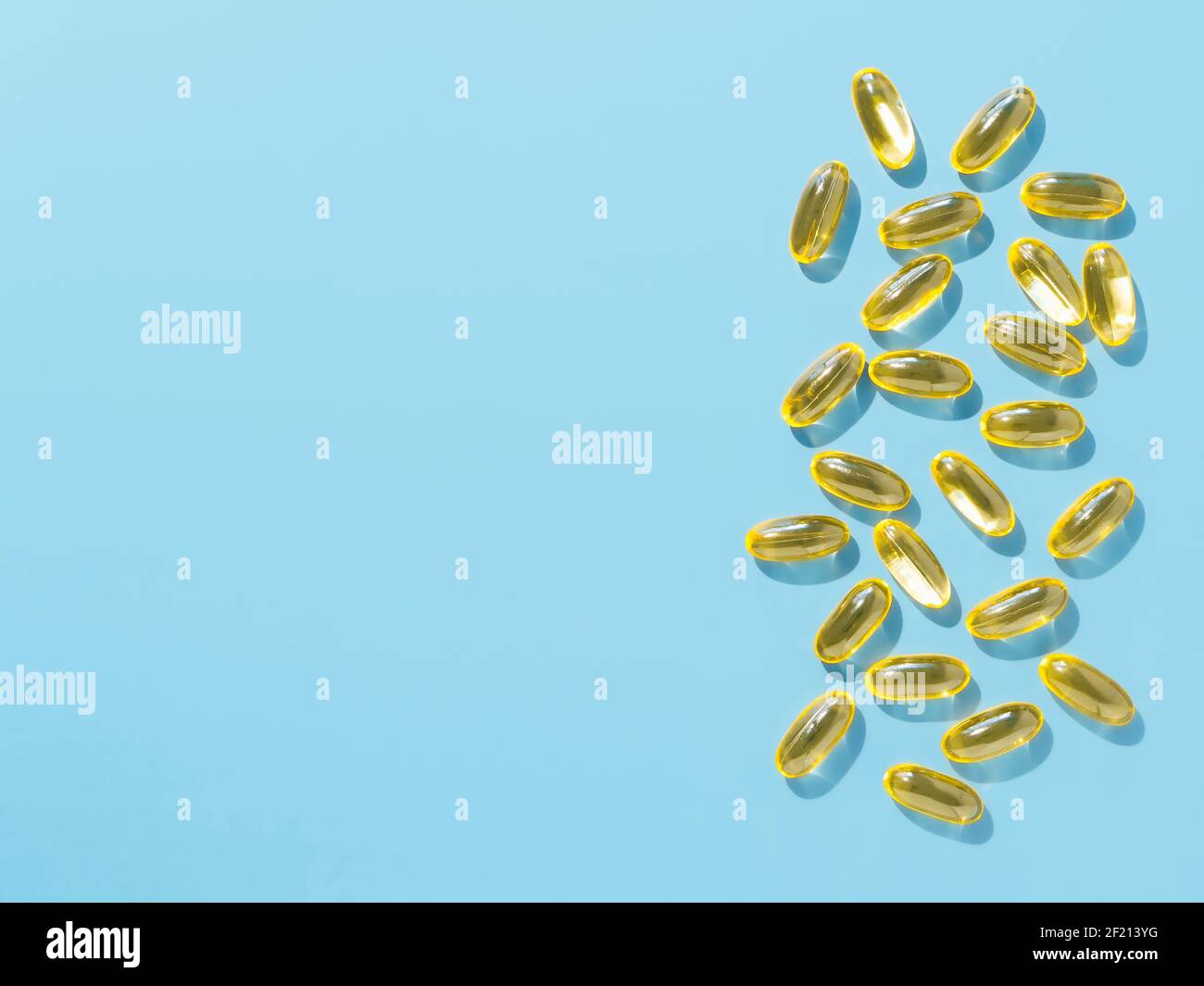 Vitamine D3, Omega ou soirée Primrose capsules de gel d'huile sur fond bleu. Vue de dessus ou à plat déposer les capsules liquides jaunes avec l'huile de supplément nutritionnel. Copier l'espace pour le texte. Banque D'Images