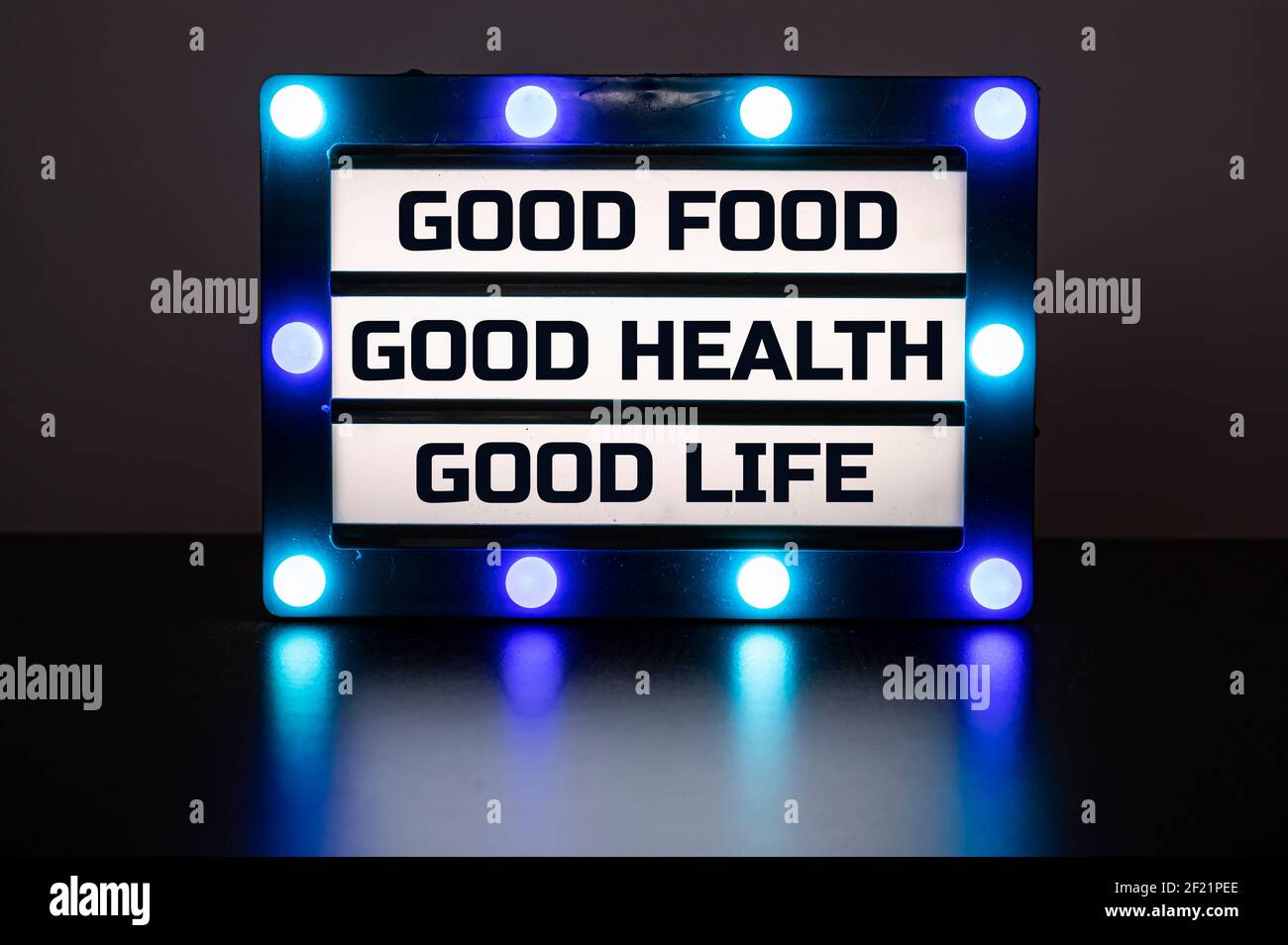 Visionneuse avec des lumières bleues dans l'obscurité avec des mots - bonne nourriture, bonne santé, bonne vie. Banque D'Images