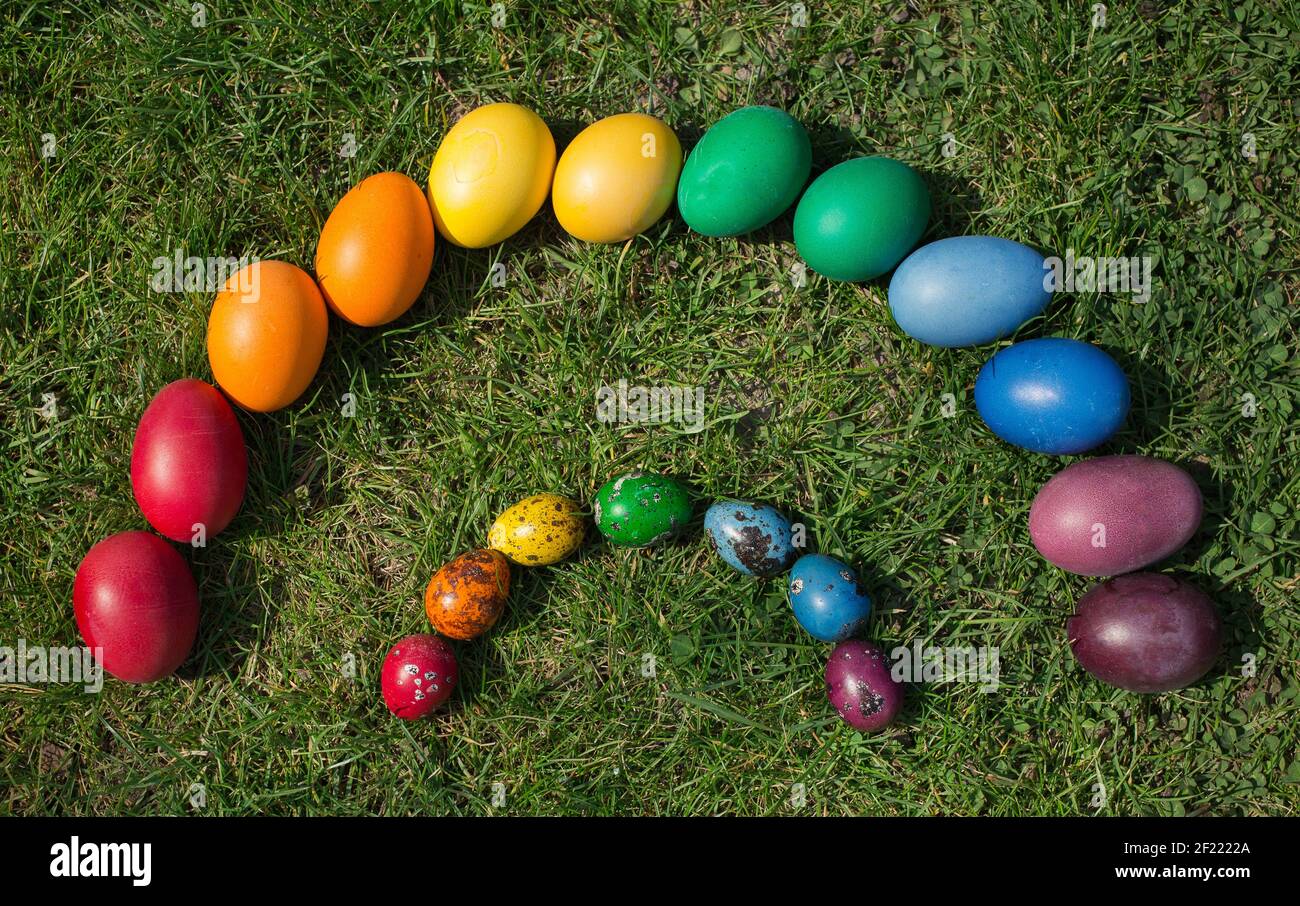 les œufs de poulet et de caille sont colorés dans des couleurs arc-en-ciel, se trouvent sur l'herbe lors d'un soleil vacances de printemps. Traditions familiales. Joyeuses Pâques Banque D'Images