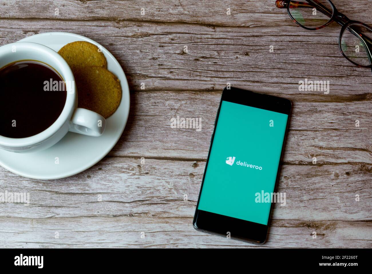 Un téléphone portable ou portable posé sur une table Avec l'application de livraison Deliveroo ouverte Banque D'Images