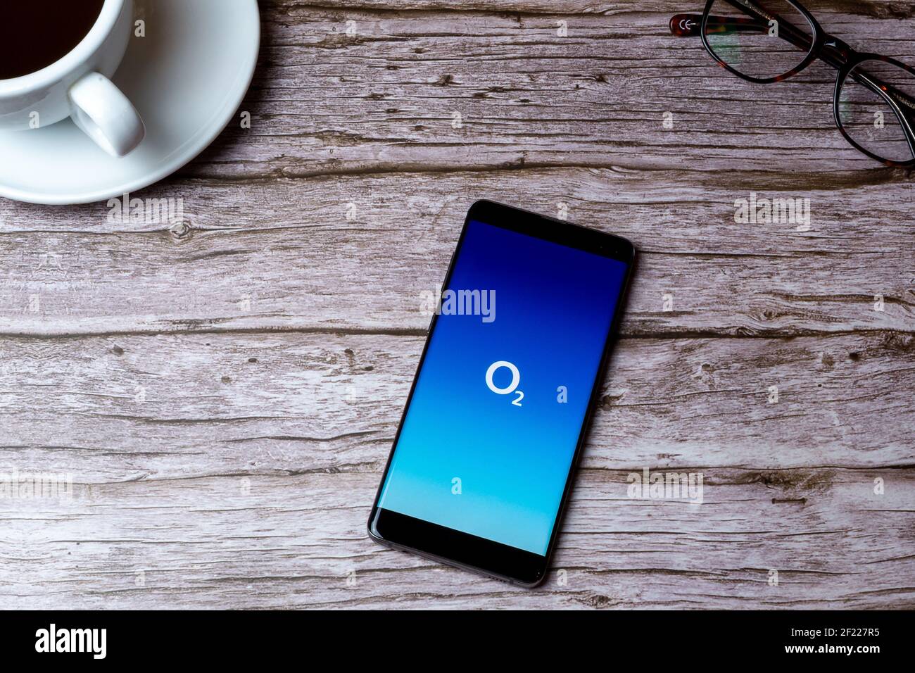 Un téléphone portable ou mobile posé sur un bois Table ou bureau avec l'application O2 Phone ouverte Banque D'Images