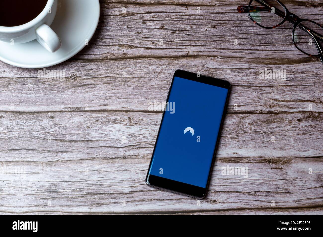 Un téléphone portable ou mobile posé sur un bois Table ou bureau avec l'application Nord VPN ouverte Banque D'Images