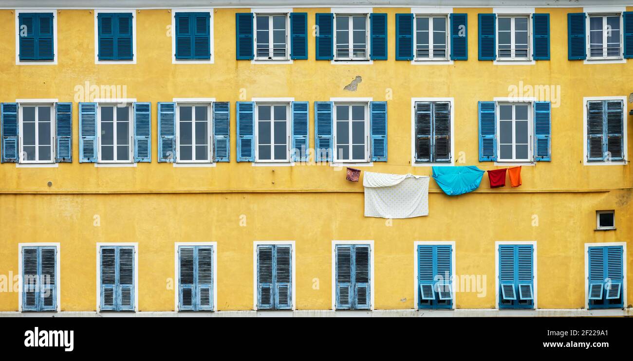 Façade jaune et bleue avec buanderie à Bastia, Corse Banque D'Images