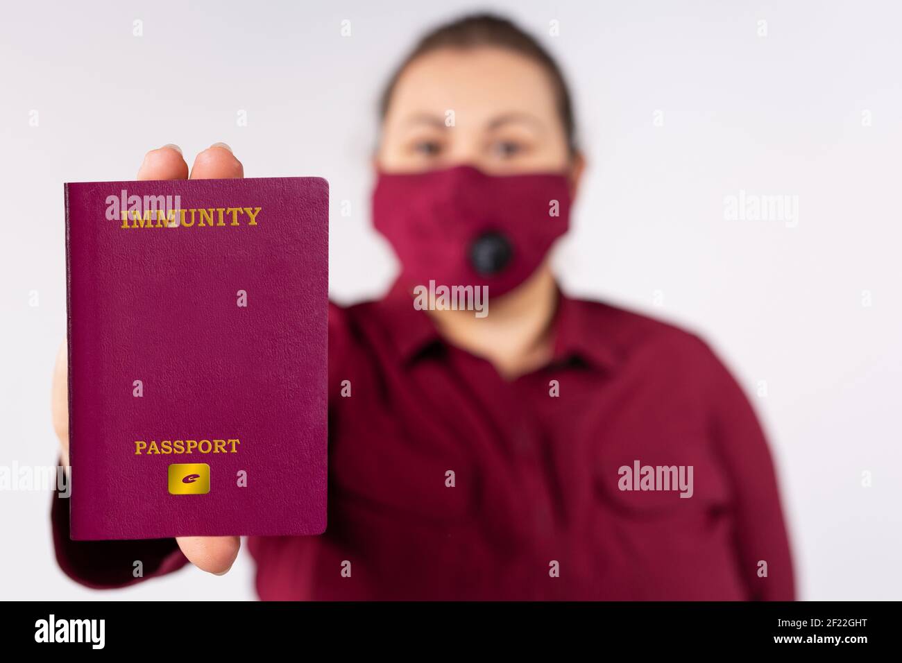Femme avec masque de protection marron portant immunité coronavirus électronique Passport. Concept de déplacement libre et de fin de restriction. Gris Banque D'Images