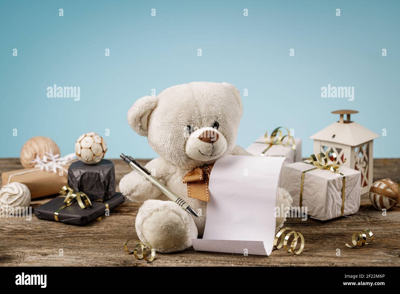 Ours en peluche blanc ou brun clair avec liste de cadeaux ou de shopping vide et décorations de noël brillantes et étincelantes. Banque D'Images