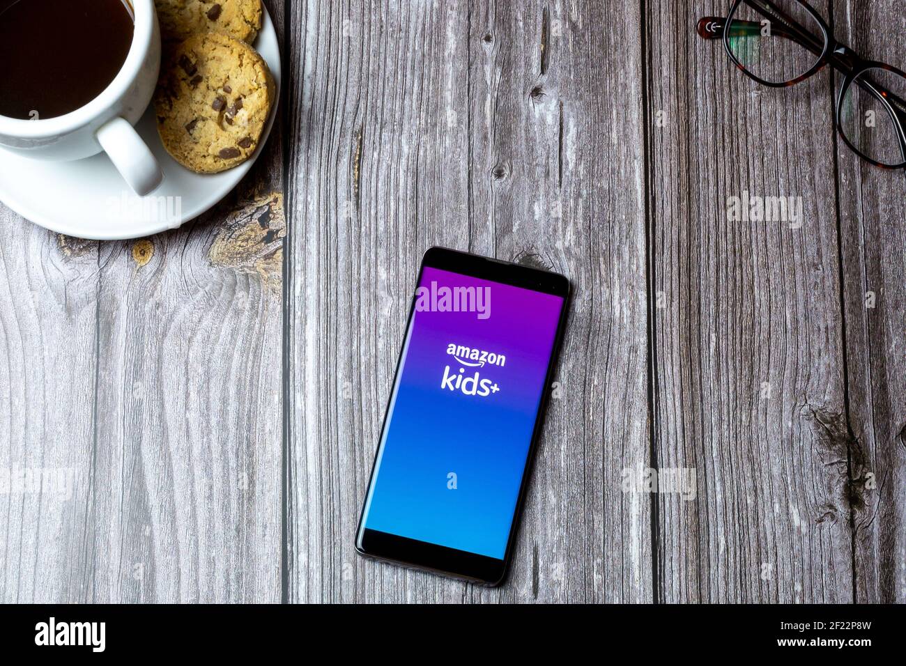 Un téléphone portable ou mobile posé sur un bois Table avec l'application Amazon Kids plus ouverte à l'écran Banque D'Images