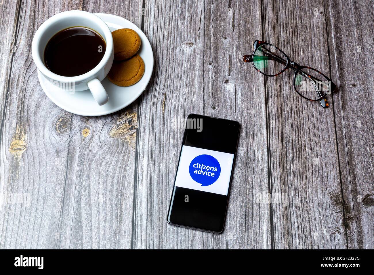 Un téléphone portable ou mobile posé sur un bois Tableau avec le logo du Bureau de conseils aux citoyens à l'écran Banque D'Images