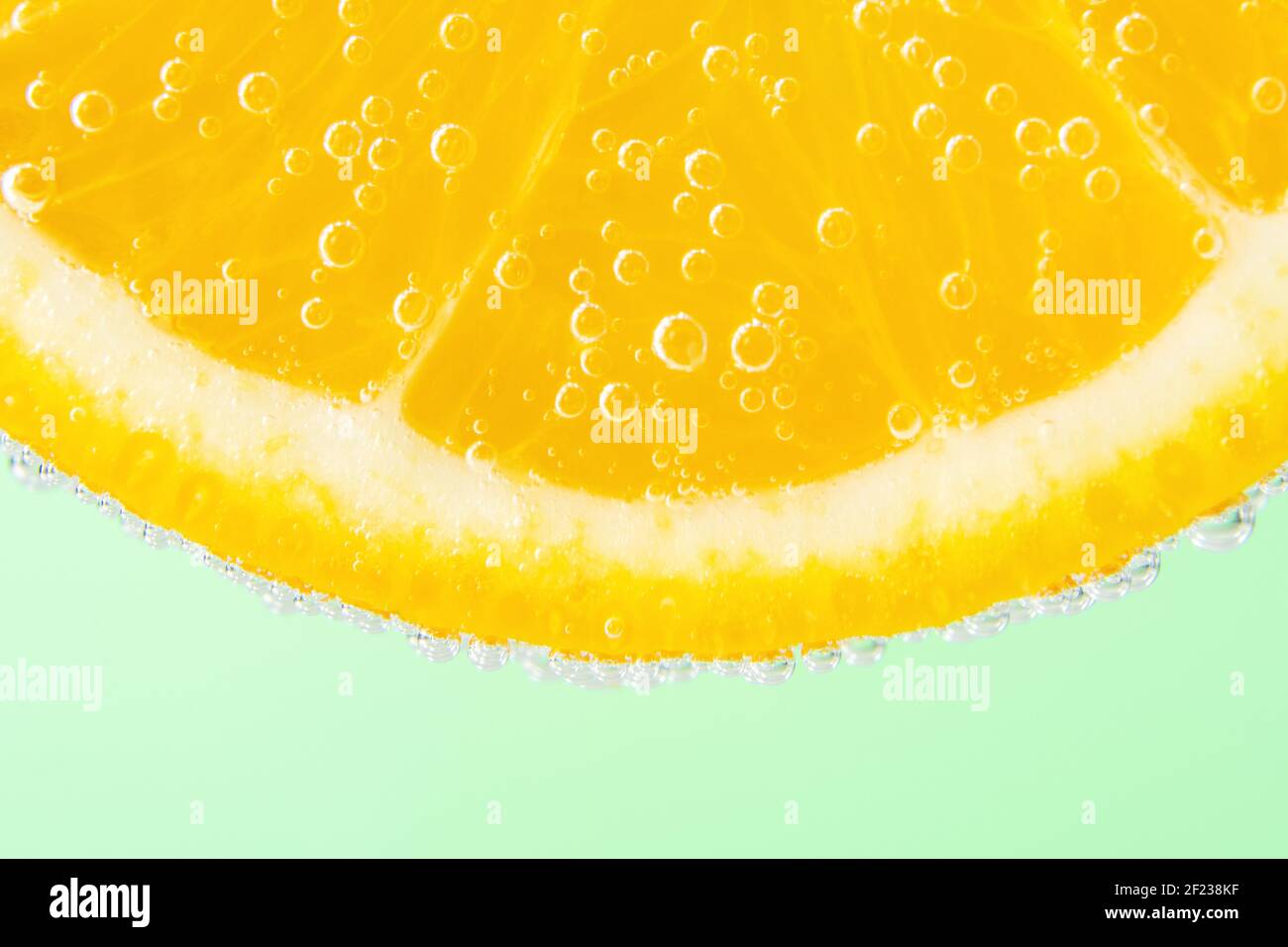 Vue rapprochée d'une tranche d'orange dans de l'eau sodée avec des bulles. Concept de boisson d'été. Banque D'Images