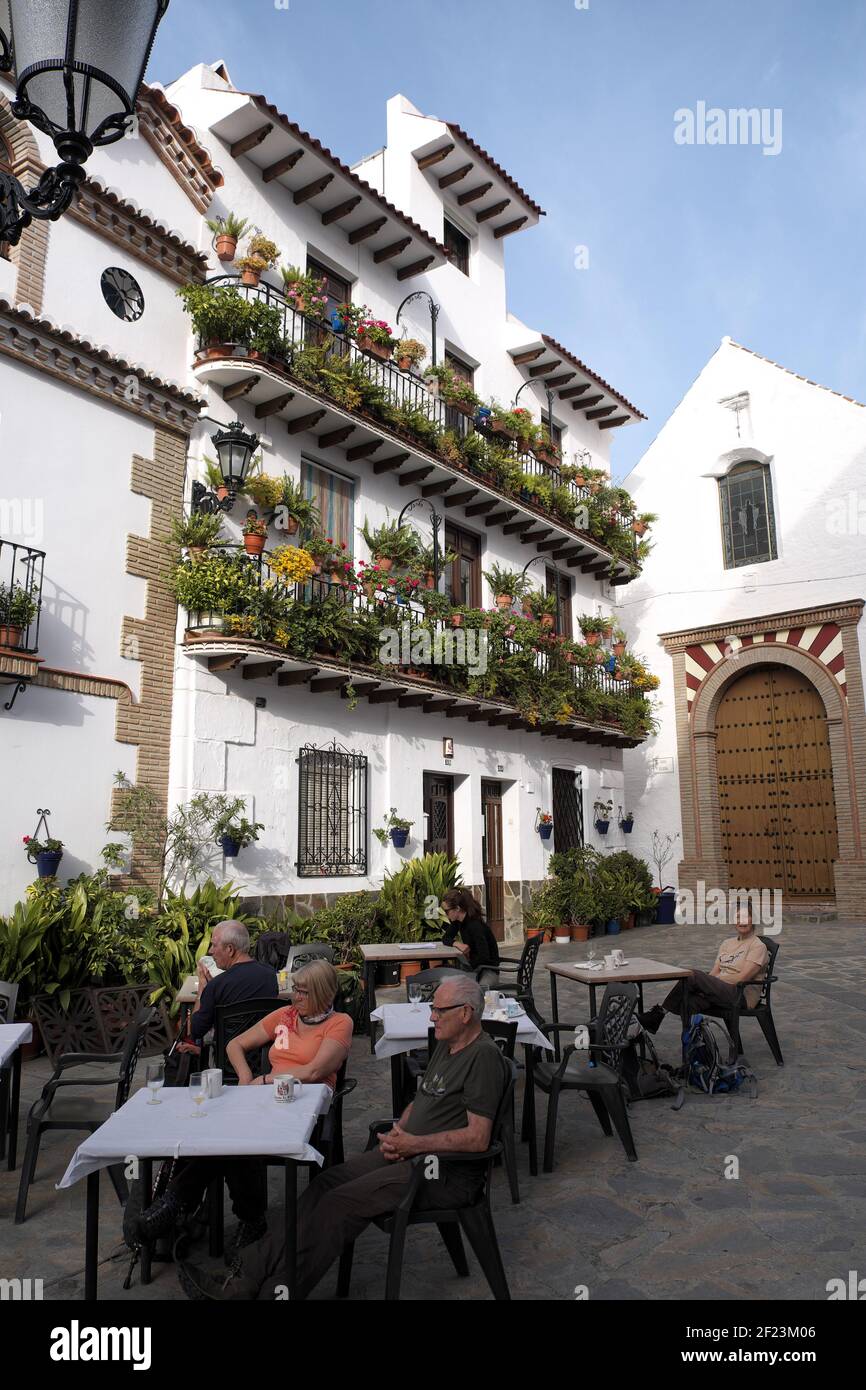 Touristes devant un hôtel dans le centre de Canillas de Ambaida, Andalousie, Espagne. Banque D'Images