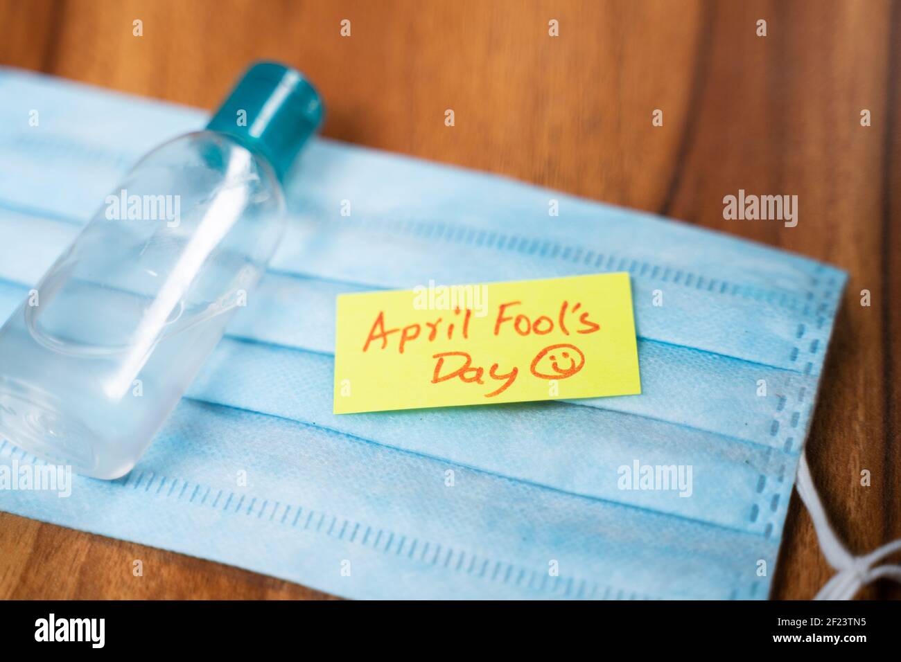 Avril Fools jour pense-bête sur le masque médical avec Bouteille de désinfectant pour les mains sur la table - concept des mousses d'avril célébrations de jour pendant le coroanvirus Banque D'Images