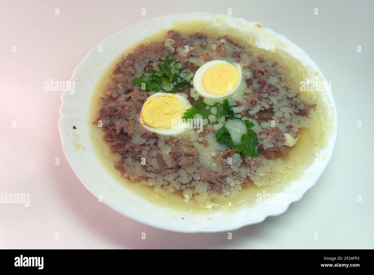 gelée d'aspiques à la viande, aux œufs et au persil frais, faite avec un bouillon d'os épais et riche, congelée dans une élégante assiette en porcelaine blanche. y compris le chemin d'écrêtage f Banque D'Images