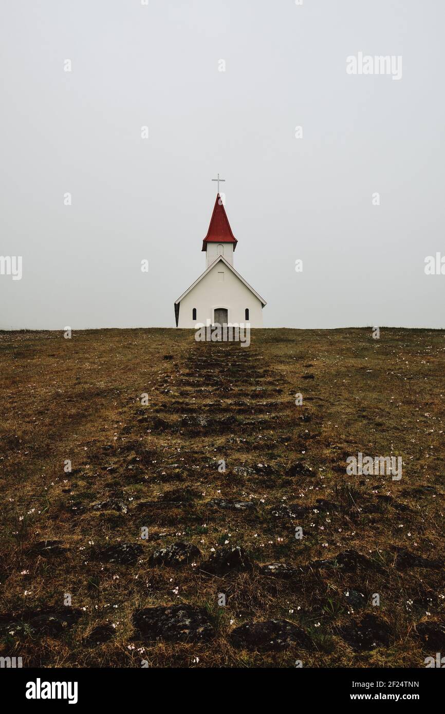 La petite église Breidavik et les marches dans le bas sombre Cloud Islande paysage des Westfjords - le minimalisme de l'islande Banque D'Images