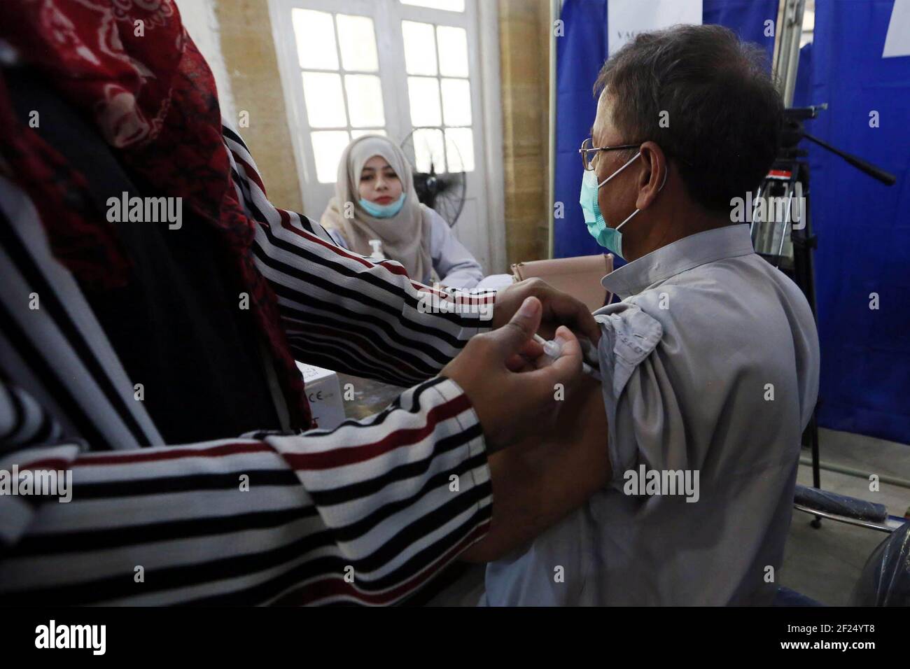 (210311) -- KARACHI, 11 mars 2021 (Xinhua) -- UN citoyen âgé reçoit une dose du vaccin COVID-19 dans un centre de vaccination de la ville portuaire de Karachi, dans le sud du Pakistan, le 10 mars 2021. Le Pakistan a commencé à vacciner mercredi les personnes âgées de 60 ans et plus. (STR/Xinhua) Banque D'Images