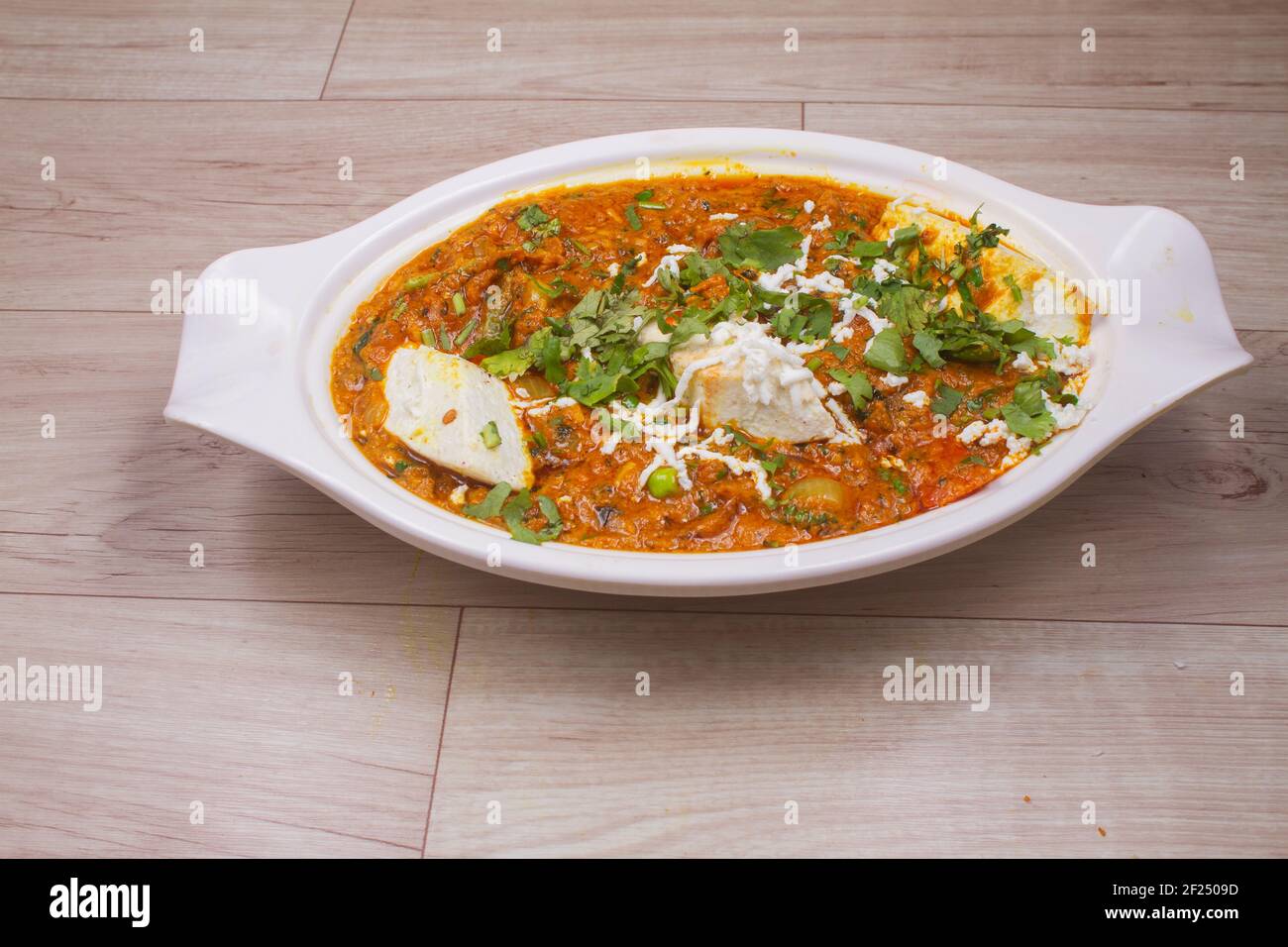 Plat indien Paneer masala ou paneer lachhedar servi dans un bol sur fond en bois Banque D'Images