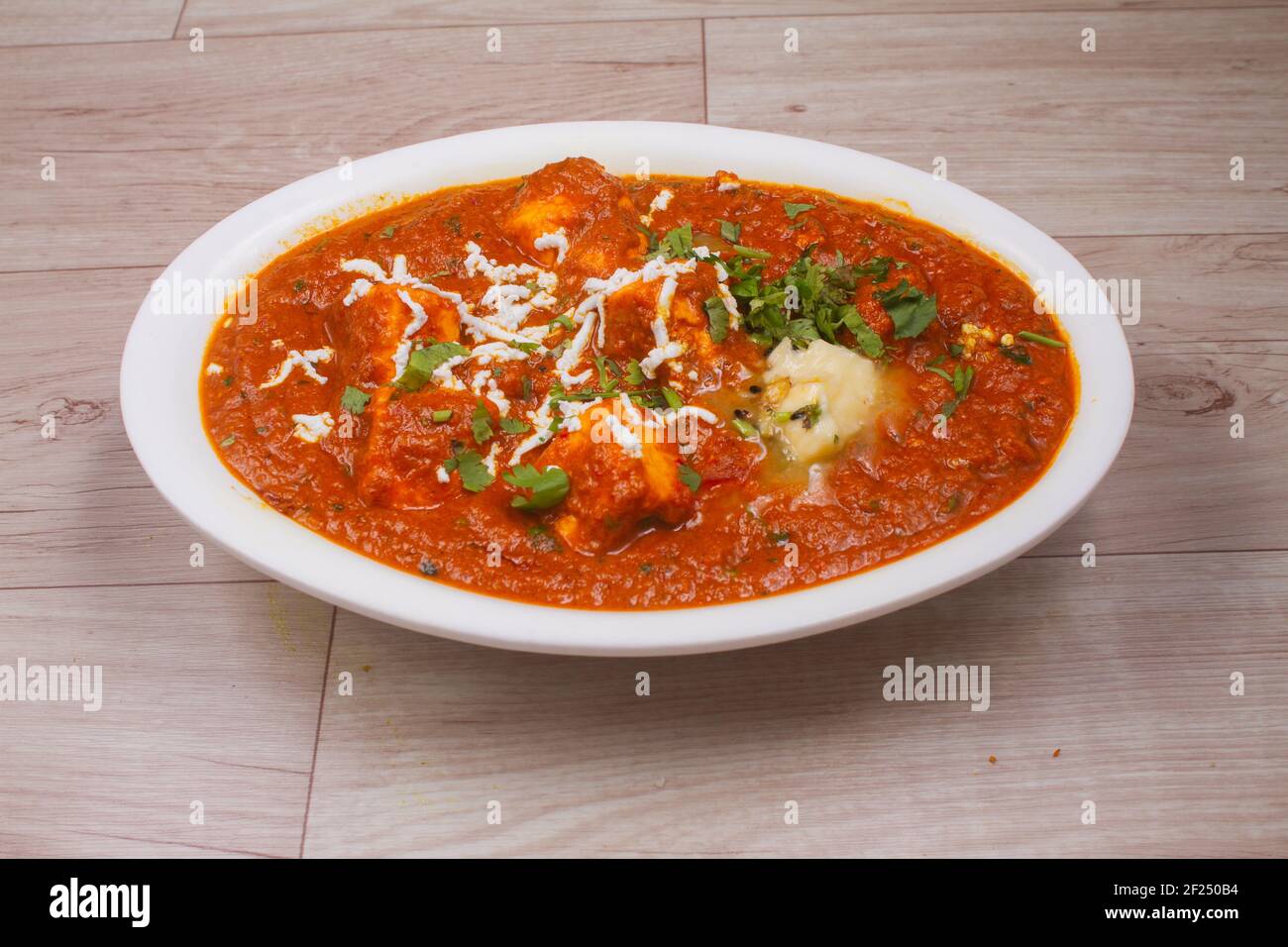 Plat indien Paneer masala ou paneer lachhedar servi dans un bol sur fond en bois Banque D'Images