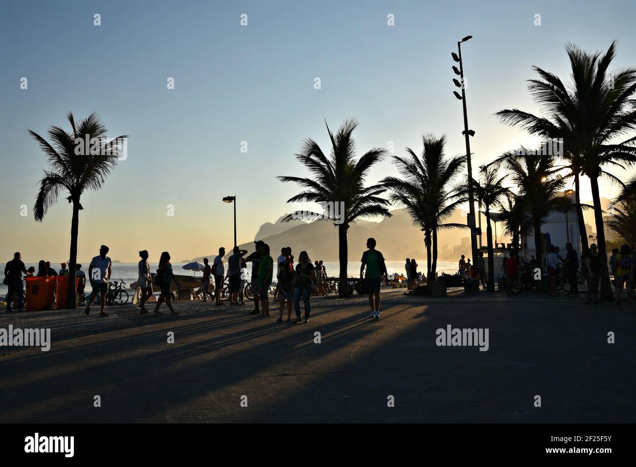 Coucher de soleil paysage avec des silhouettes de personnes sur la promenade d'Arpoador à Rio de Janeiro, Brésil. Banque D'Images