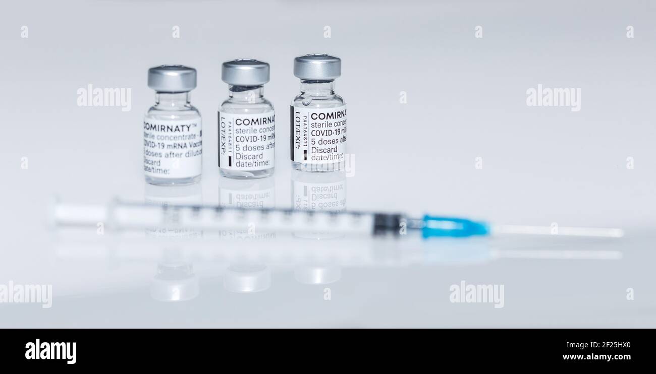 PRAGUE, CZE - 10 mars 2021. Ampoules de vaccin contre le virus du SRAS COVID-19. Vaccin à ARNm COMIRNATY sur fond blanc. Seringue avec vaccin COMIRNATY contre S. Banque D'Images