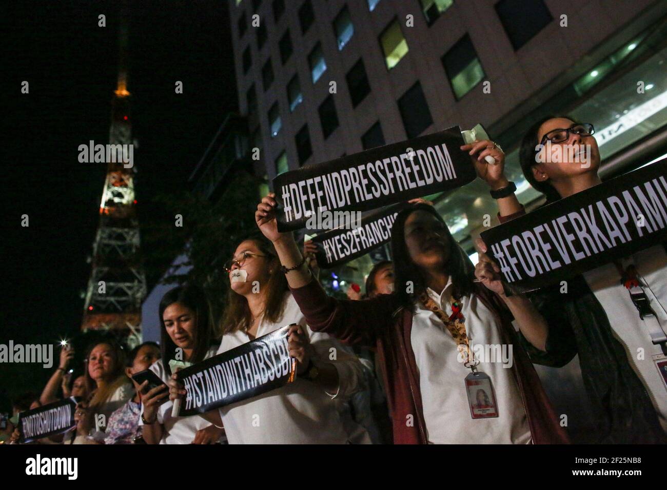 Les partisans et les employés d'ABS-CBN, le plus grand réseau de diffusion du pays, des bougies lumineuses et des slogans criants se joignent à une manifestation devant le bâtiment ABS-CBN de Manille, aux Philippines. Banque D'Images