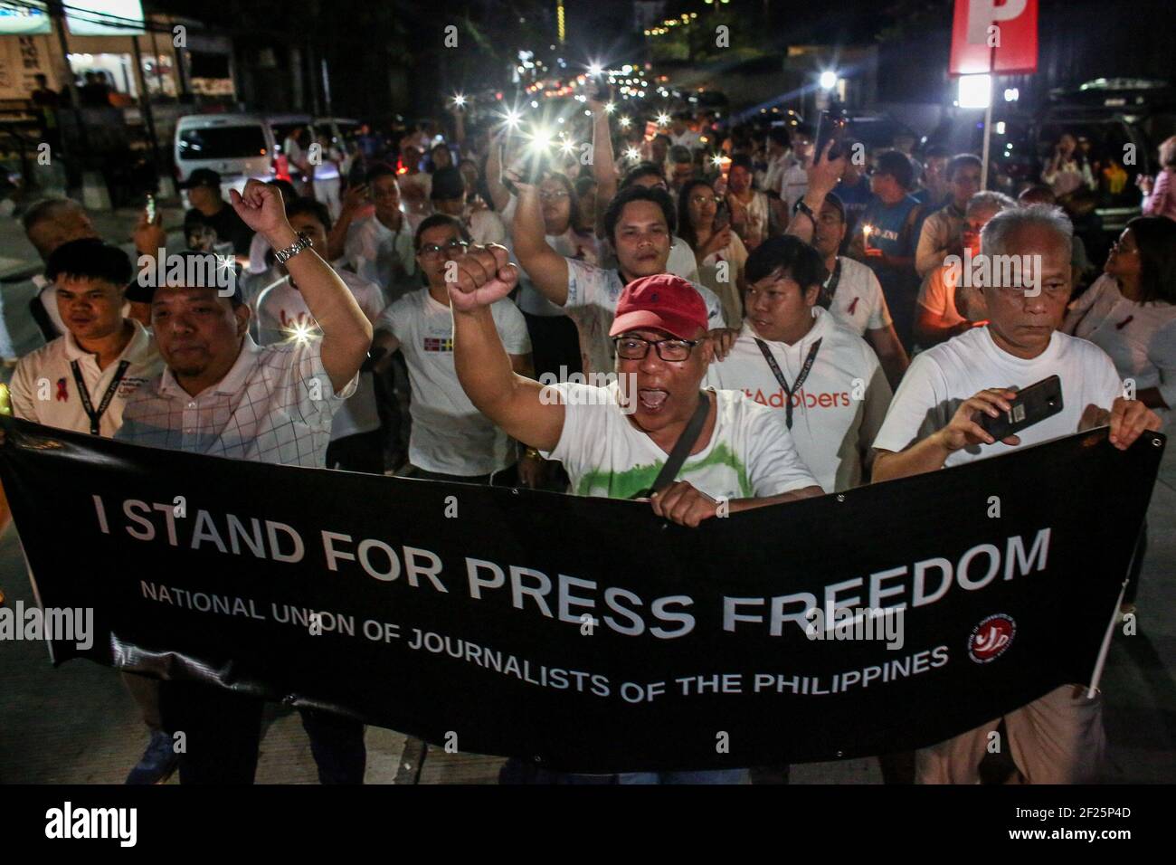 Les partisans et les employés d'ABS-CBN, le plus grand réseau de diffusion du pays, des bougies lumineuses et des slogans criants se joignent à une manifestation devant le bâtiment ABS-CBN de Manille, aux Philippines. Banque D'Images