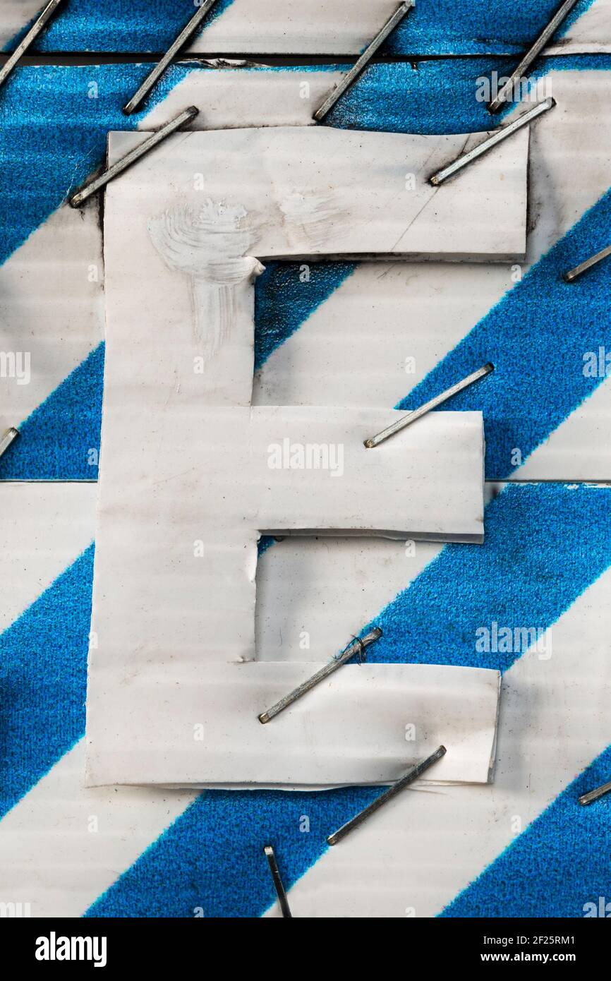 Agrafé ensemble la lettre BLANCHE A sur un bleu et un blanc arrière-plan rayé Banque D'Images