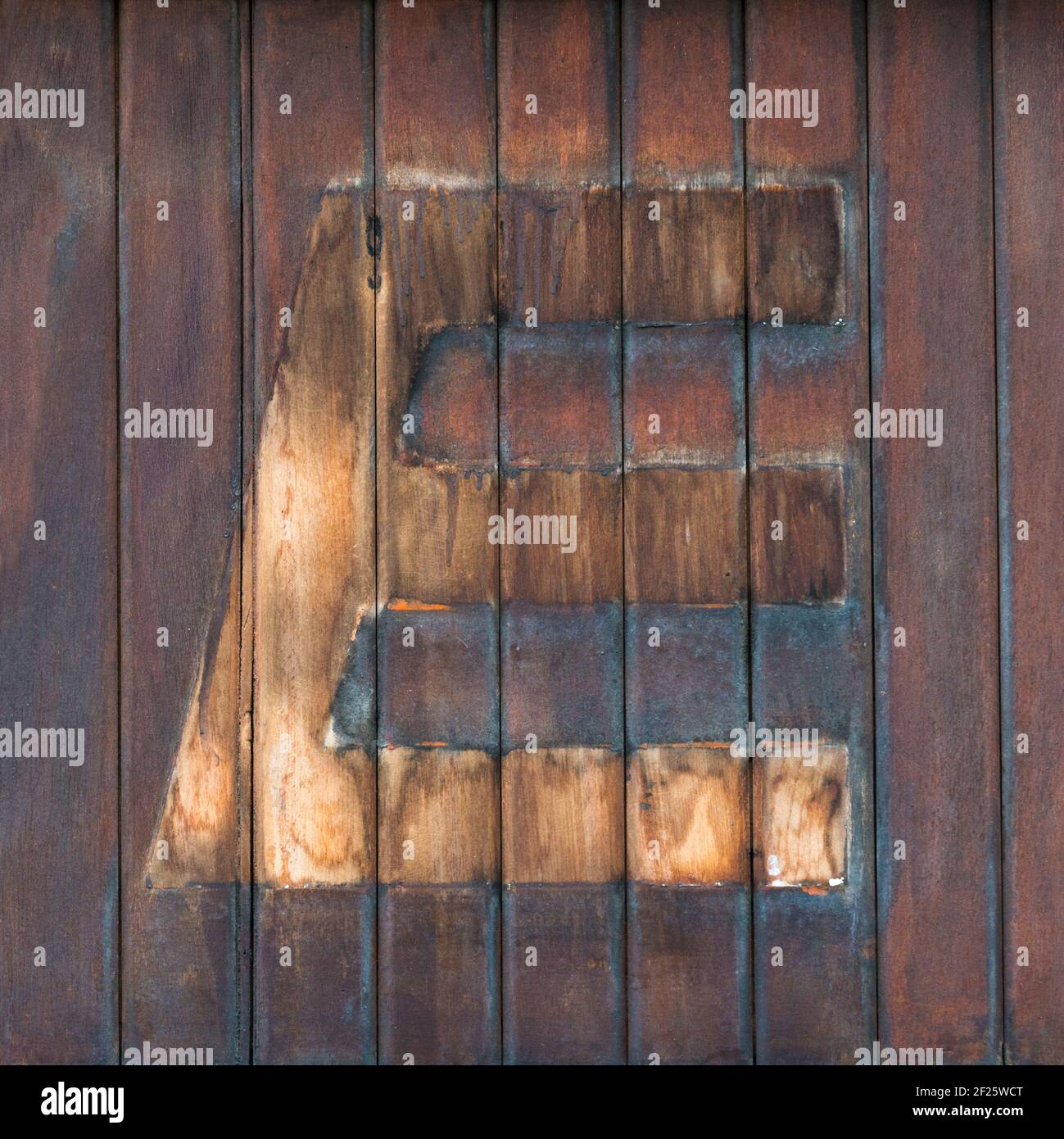 Traces de la lettre E démontée sur des planches de bois marron Banque D'Images