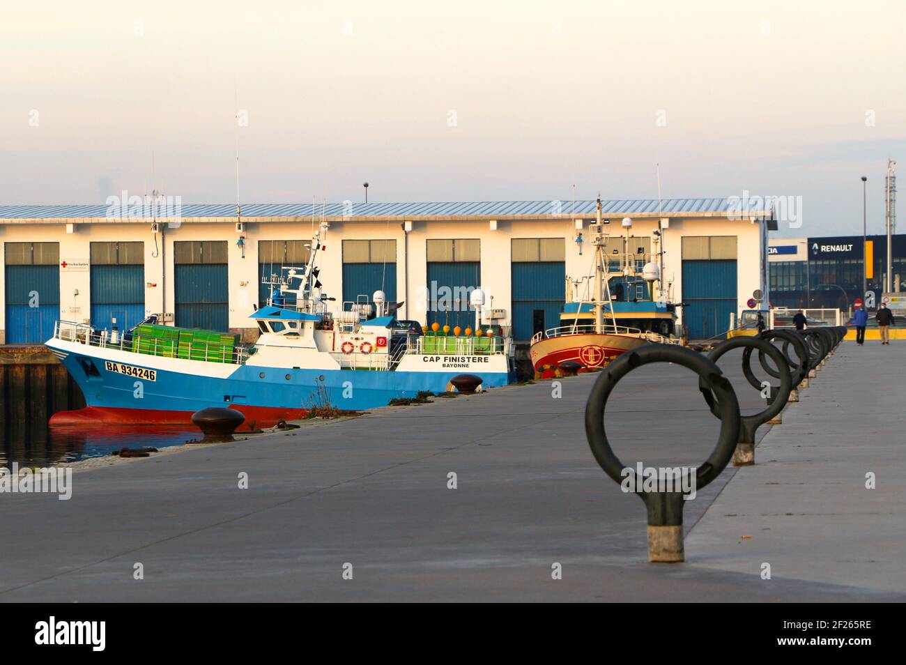 Ligne d'anneaux d'amarrage décoratifs Maliano Dock avec le chalutier français Cap Finistère et le chalutier espagnol Sukari Primero amarré le soleil du matin Banque D'Images