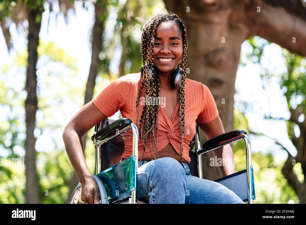 Femme en fauteuil roulant écoutant de la musique avec un casque. Banque D'Images
