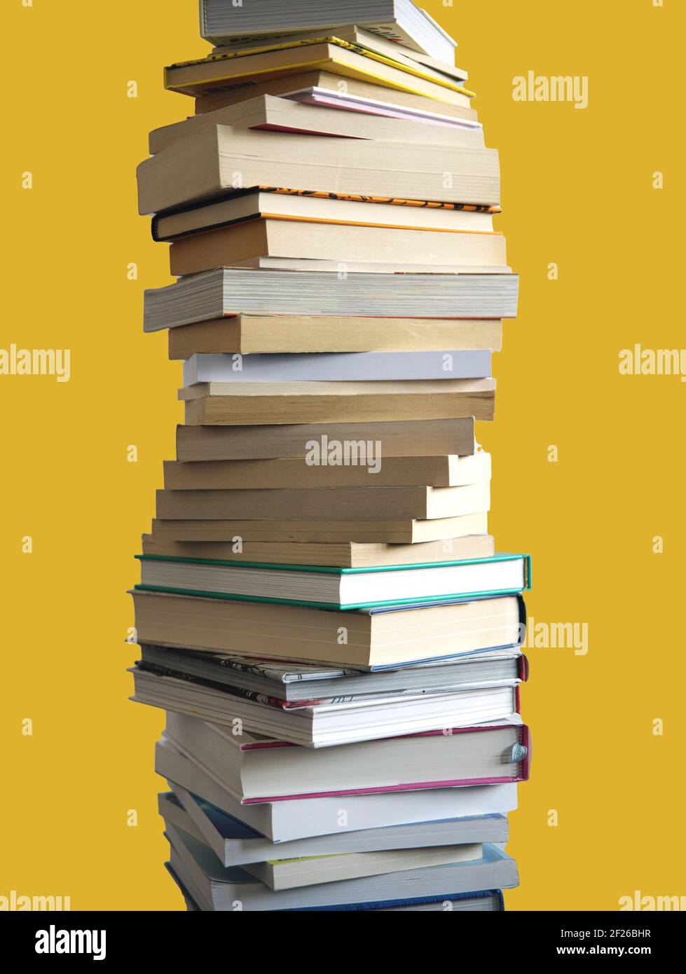 Une grande pile de nombreux livres empilés haut, isolé sur jaune Banque D'Images
