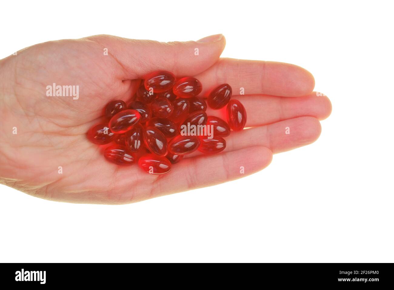 Capsules d'huile de krill. Capsules de gélatine rouge avec de l'huile de krill dans la main isolées sur fond blanc.Source d'acides gras oméga.Suppléments.diététique Banque D'Images