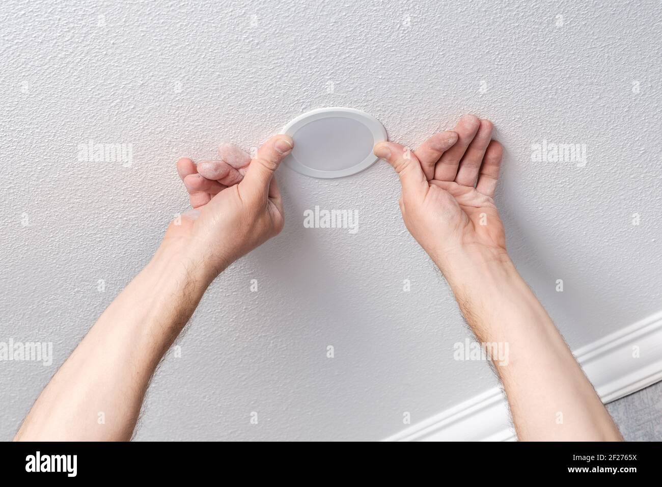 L'électricien répare ou installe à la main une ampoule LED moderne Banque D'Images