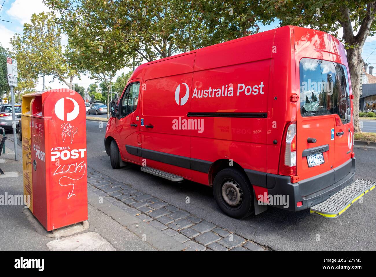 Un minibus de livraison de la poste australienne stationné à côté d'une boîte postale à Melbourne, Victoria, Australie. Banque D'Images