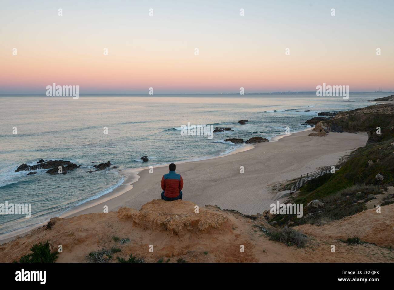 Homme voyant Praia do Malhao vue sur la plage au lever du soleil, au Portugal Banque D'Images