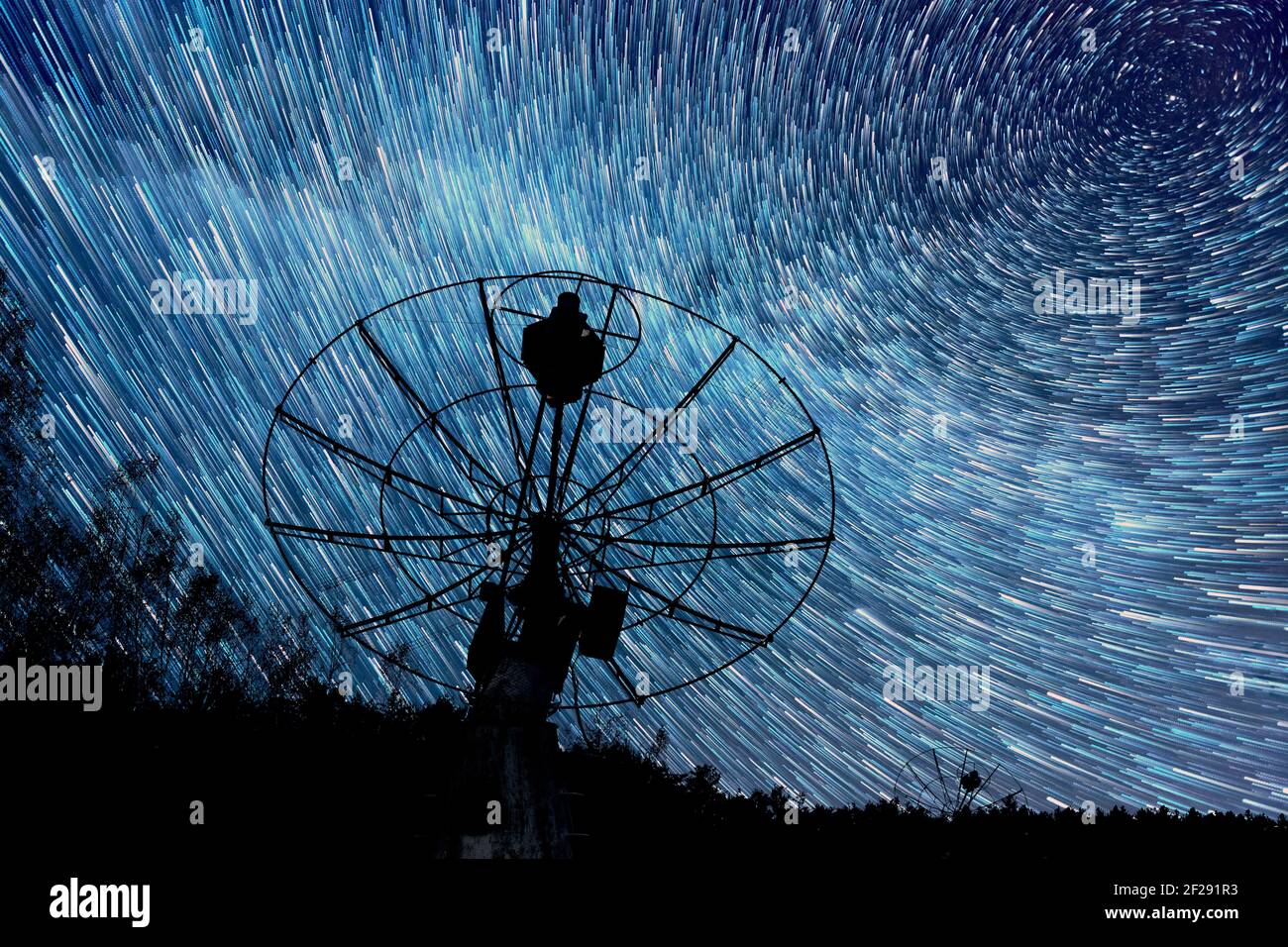 radiotelescopes silhouettes sous l'arrière-plan de courts sentiers d'étoiles Banque D'Images