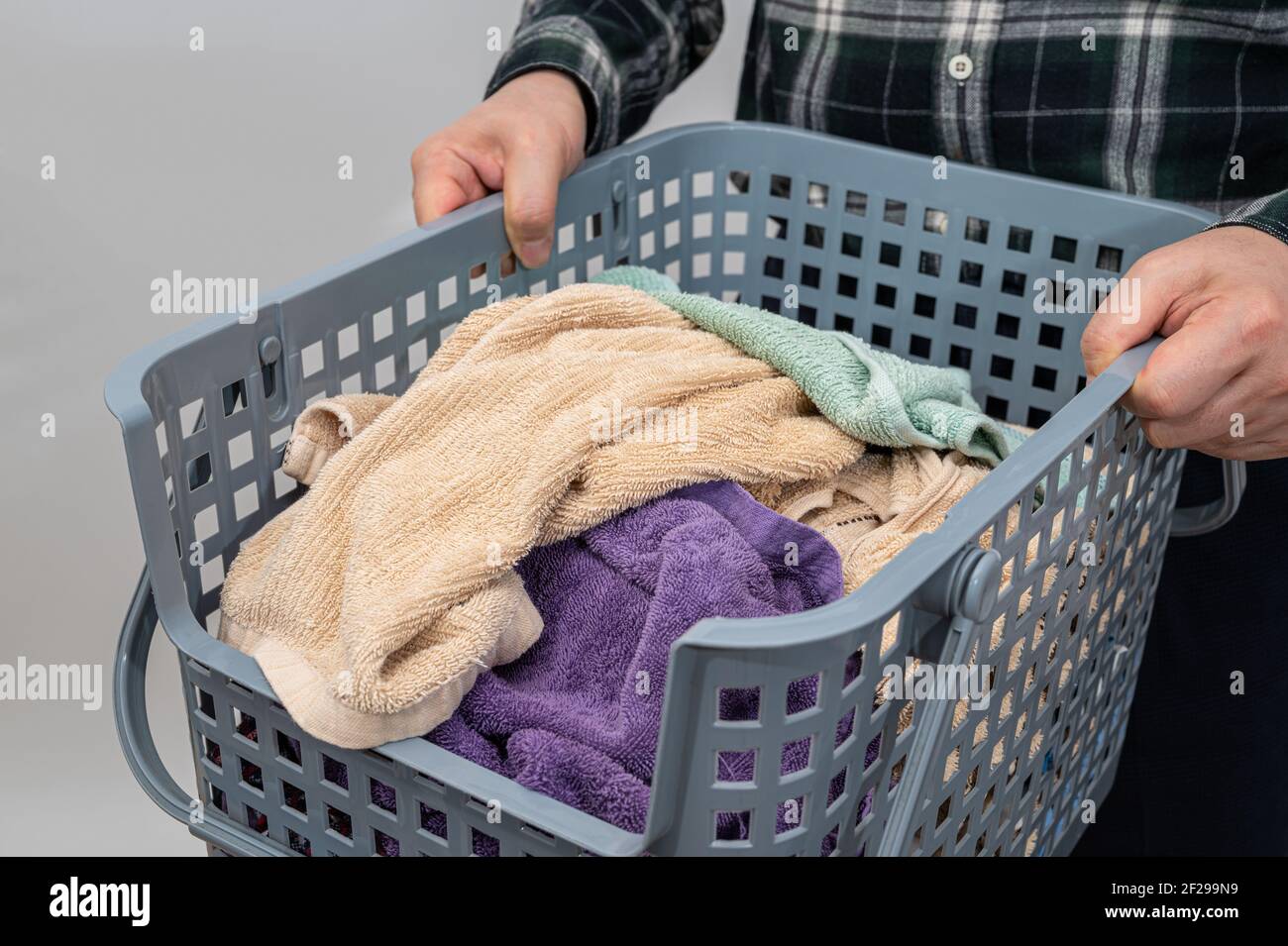 Un homme tenant un panier rempli de serviettes. Banque D'Images