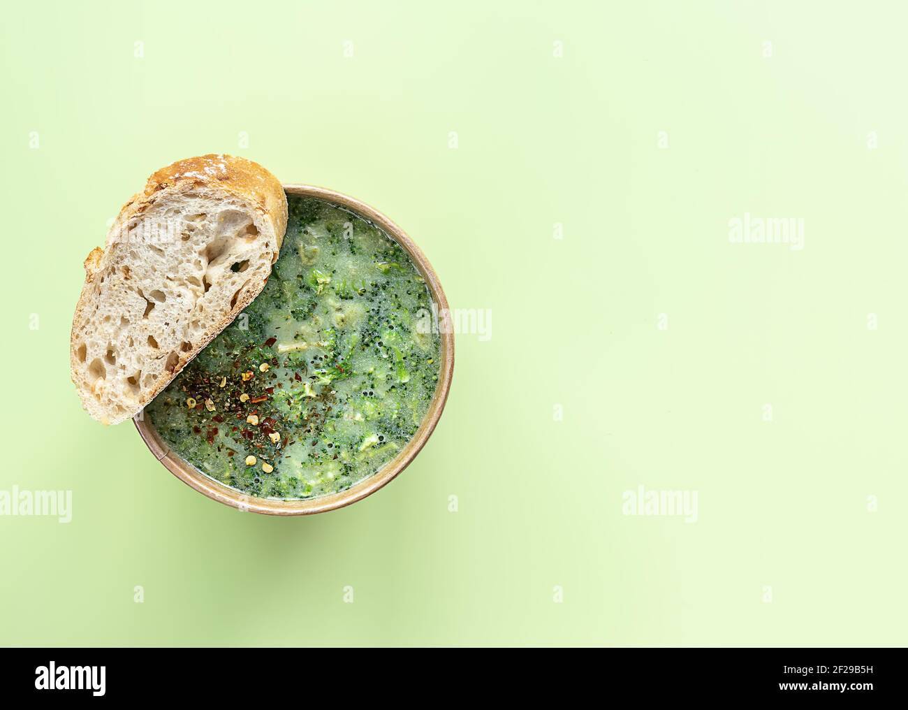 La soupe à la crème de brocoli fraîche servi du pain frais et des épices dans un récipient artisanal. Déjeuner végétarien à emporter. Banque D'Images