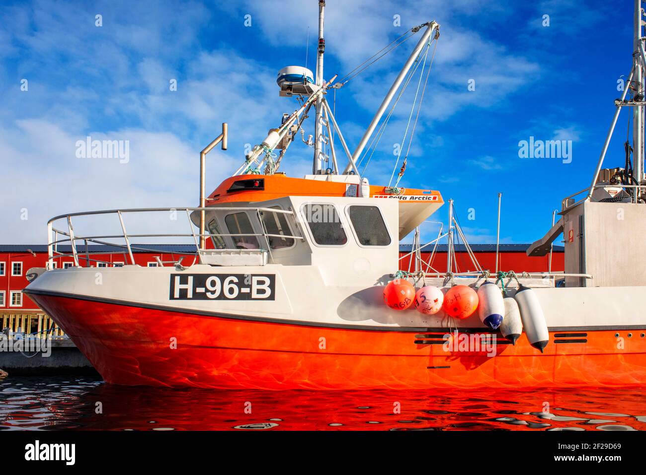 Bateau de pêche rouge amarré par une jetée à Reine, Moskenes, Île Moskenesøya, îles Lofoten, Norvège. Banque D'Images