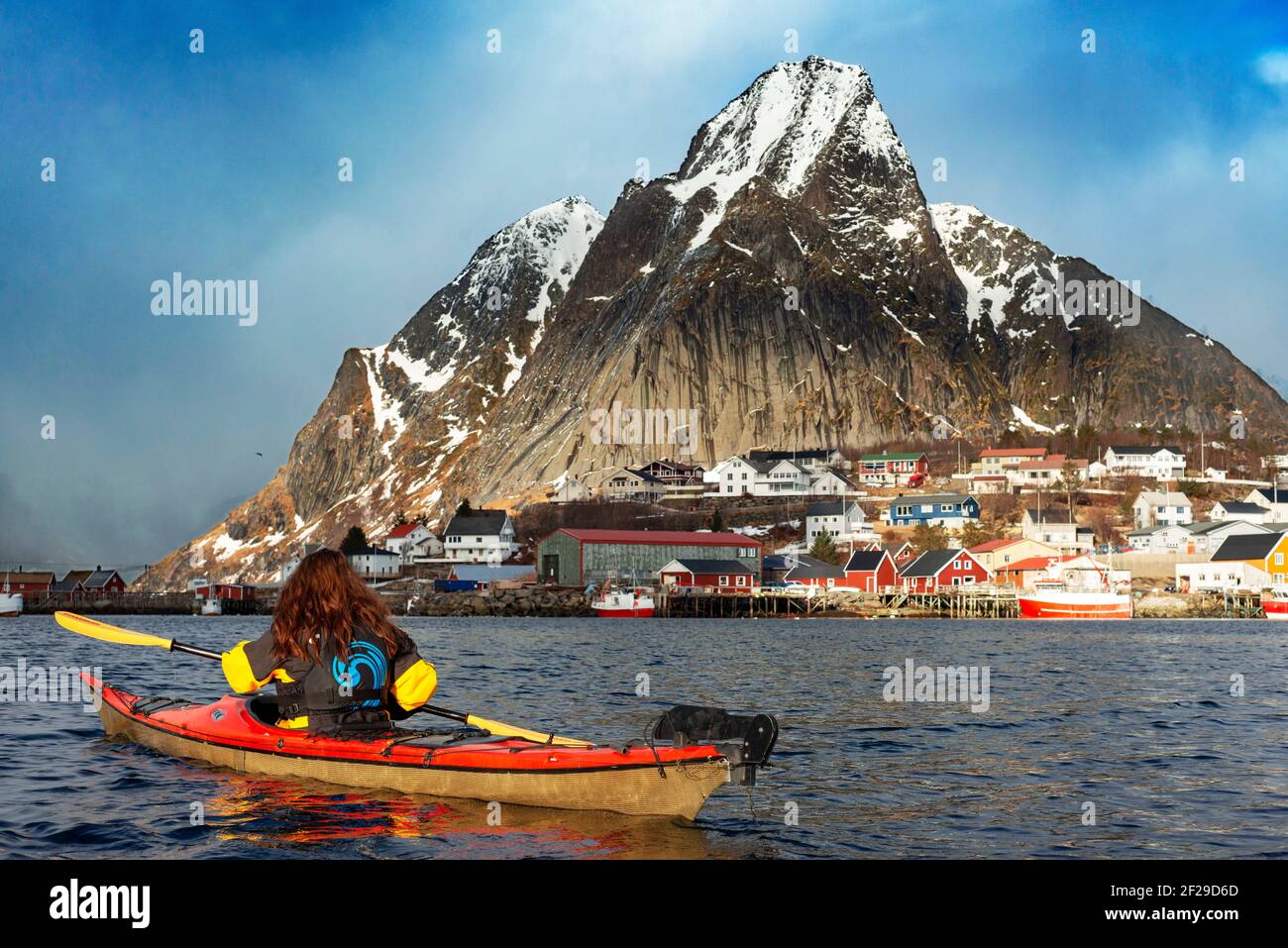 Kayak à Reine, Moskenes, Île de Moskenesøya, îles Lofoten, Norvège. Paysage avec le pic d'Olstiden. Banque D'Images