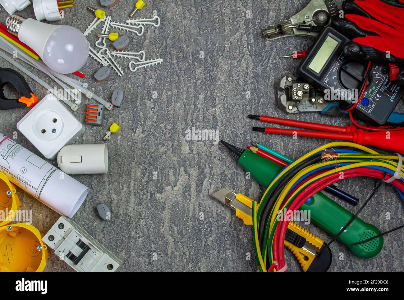 Outils électriques et un ensemble de composants à utiliser dans installations électriques sur fond gris avec un emplacement pour texte Banque D'Images