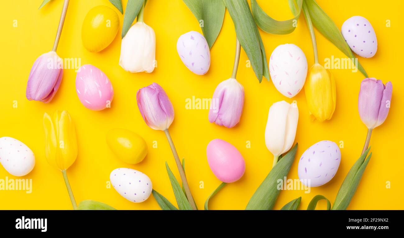 Carte de vœux de Pâques. Oeufs de pâques multicolores et tulipes sur fond jaune. Concept Pâques - image Banque D'Images