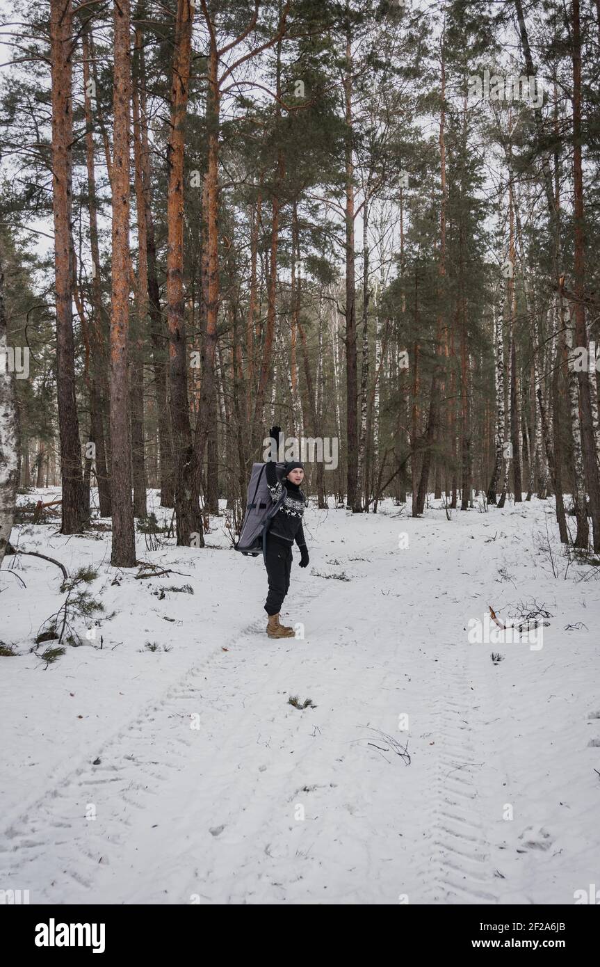 Un homme fait des vagues sur sa main, un grand sac à dos pour une planche gonflable Banque D'Images